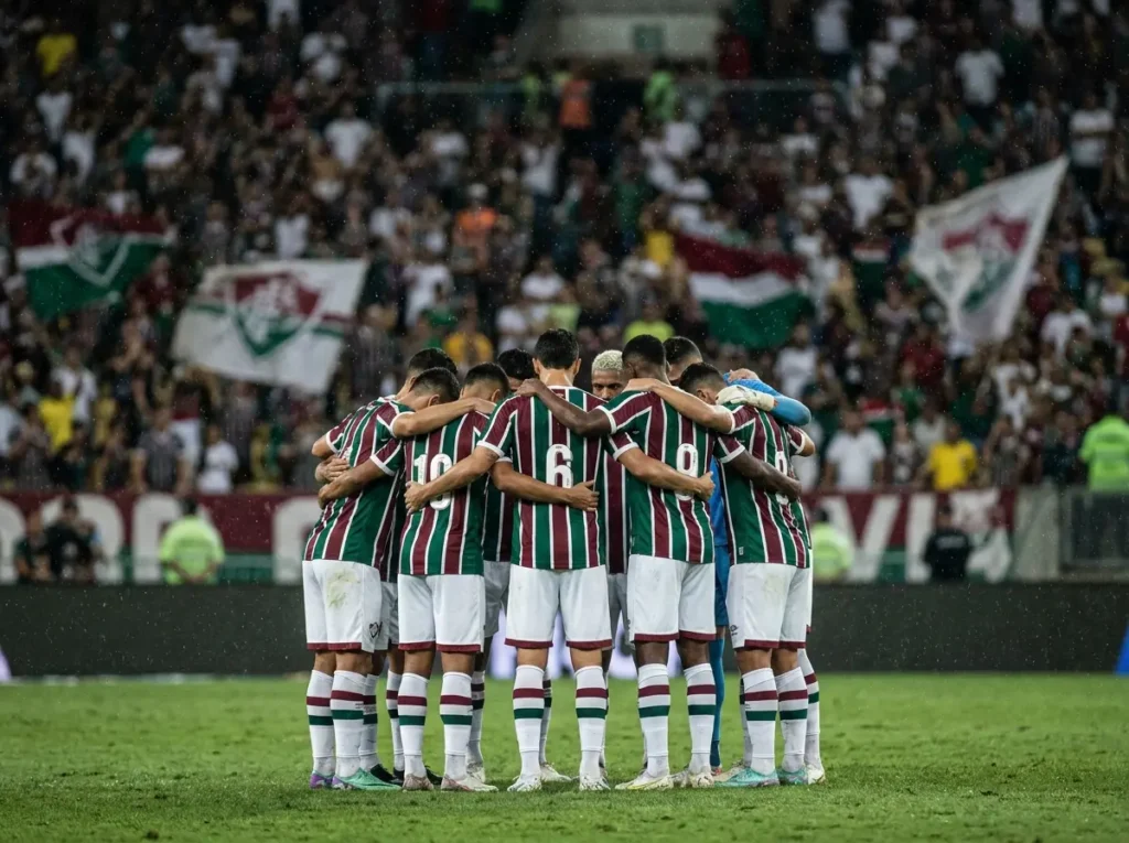 Jogadores do Fluminense de costas abraçados e cabisbaixos no campo após a partida
