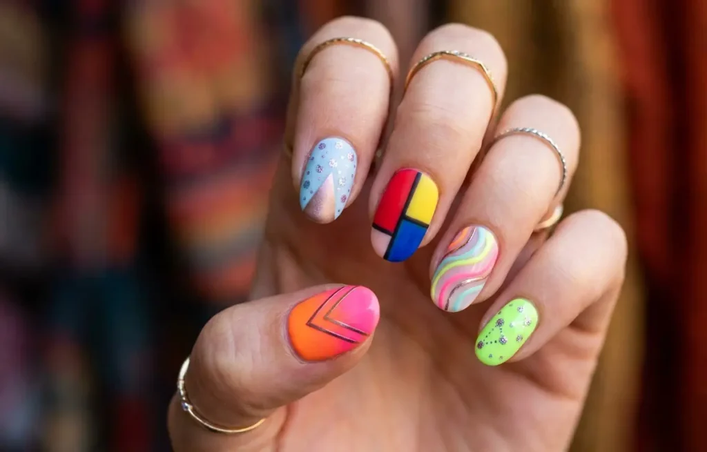 Mão feminina em plano médio com unhas coloridas e nail art vibrante 2026, fundo desfocado