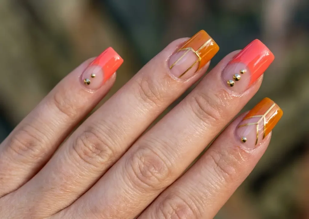 Unhas quadradas decoradas 2026: ideias minimalistas que alongam Mão feminina com unhas quadradas decoradas em tons quentes e detalhes dourados